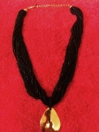 Black beaded rope necklace with gold teardrop